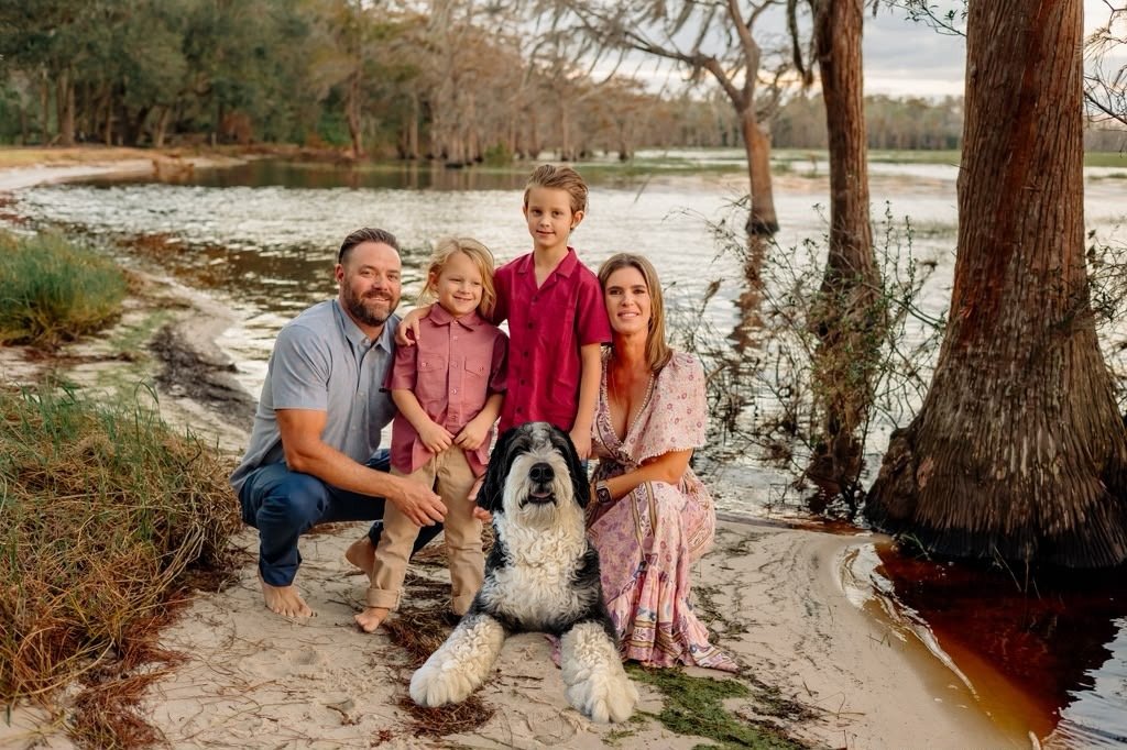 The Meadows & Mutts family with their Bernedoodle beside a Florida lake